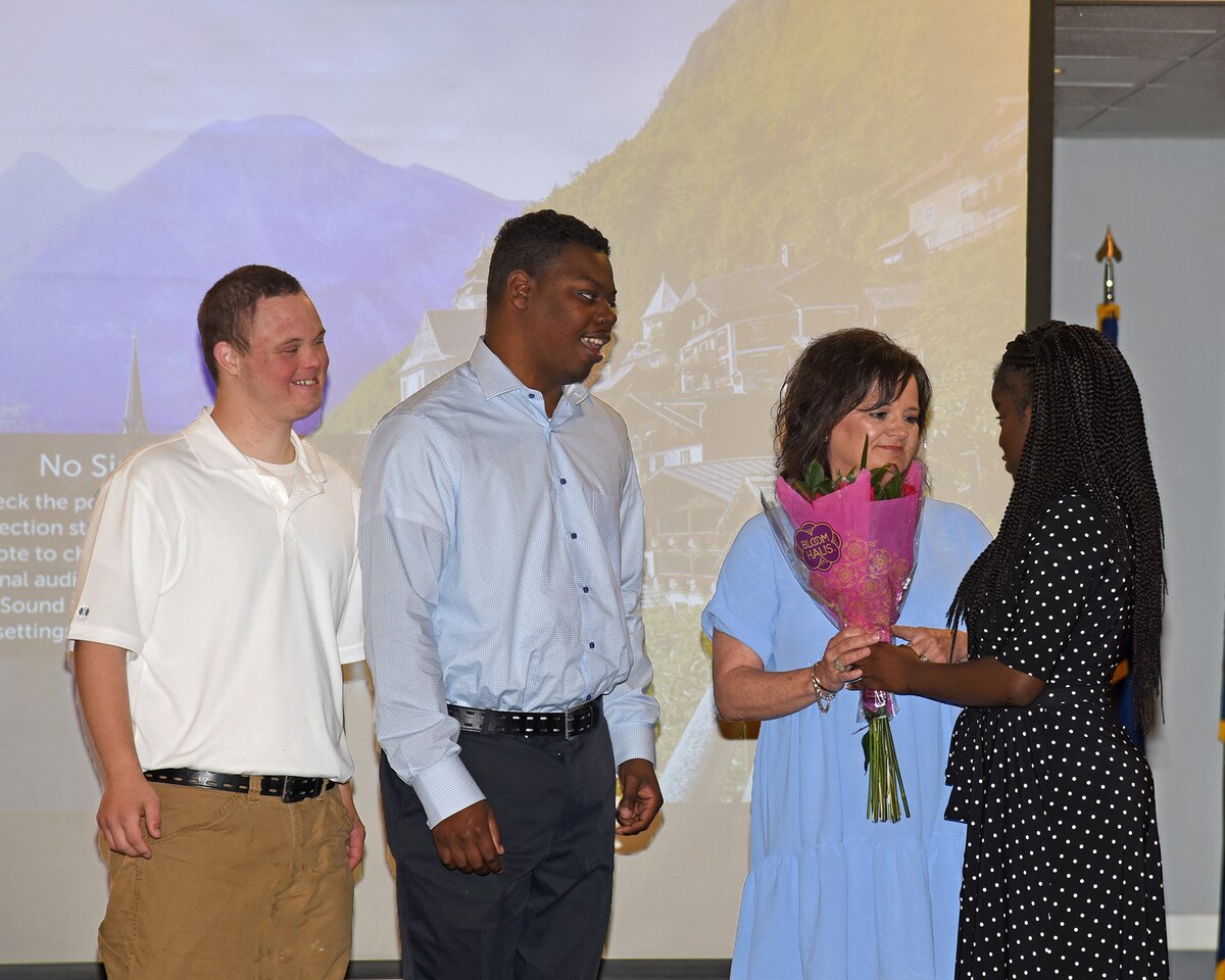 Chandler Blakely, Juwan Woods and Makyia Bibbs present flowers to Ms. Katie Stevens, their instructor. 